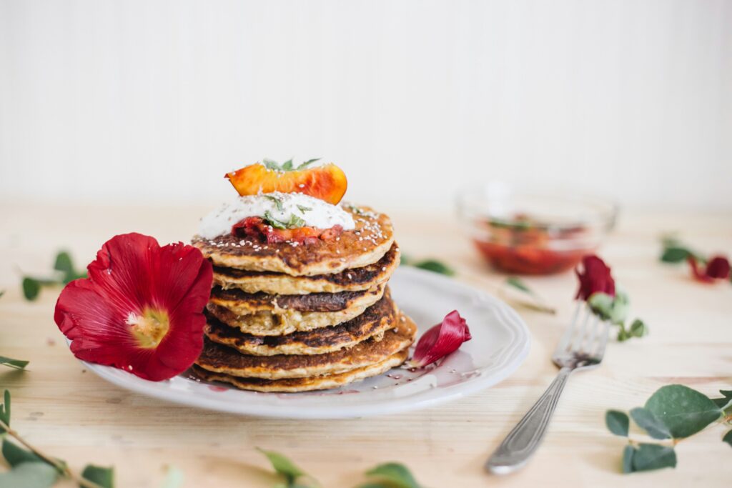 Perfectly cooked stack of fluffy American pancakes with syrup and butter.