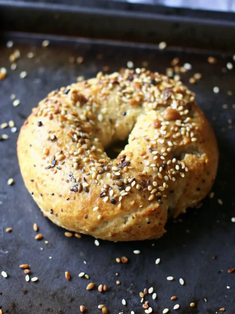 Greek Yogurt Bagels Overhead shot of simple ingredients: a bowl of plain Greek yogurt, a pile of self-rising flour, a small bowl of poppy seeds, and another of sesame seeds, neatly arranged on a wooden cutting board next to a marble countertop. Fresh herbs subtly blurred in the background, bathed in natural morning light. Soft shadows, warm tones. NO HANDS OR PEOPLE.