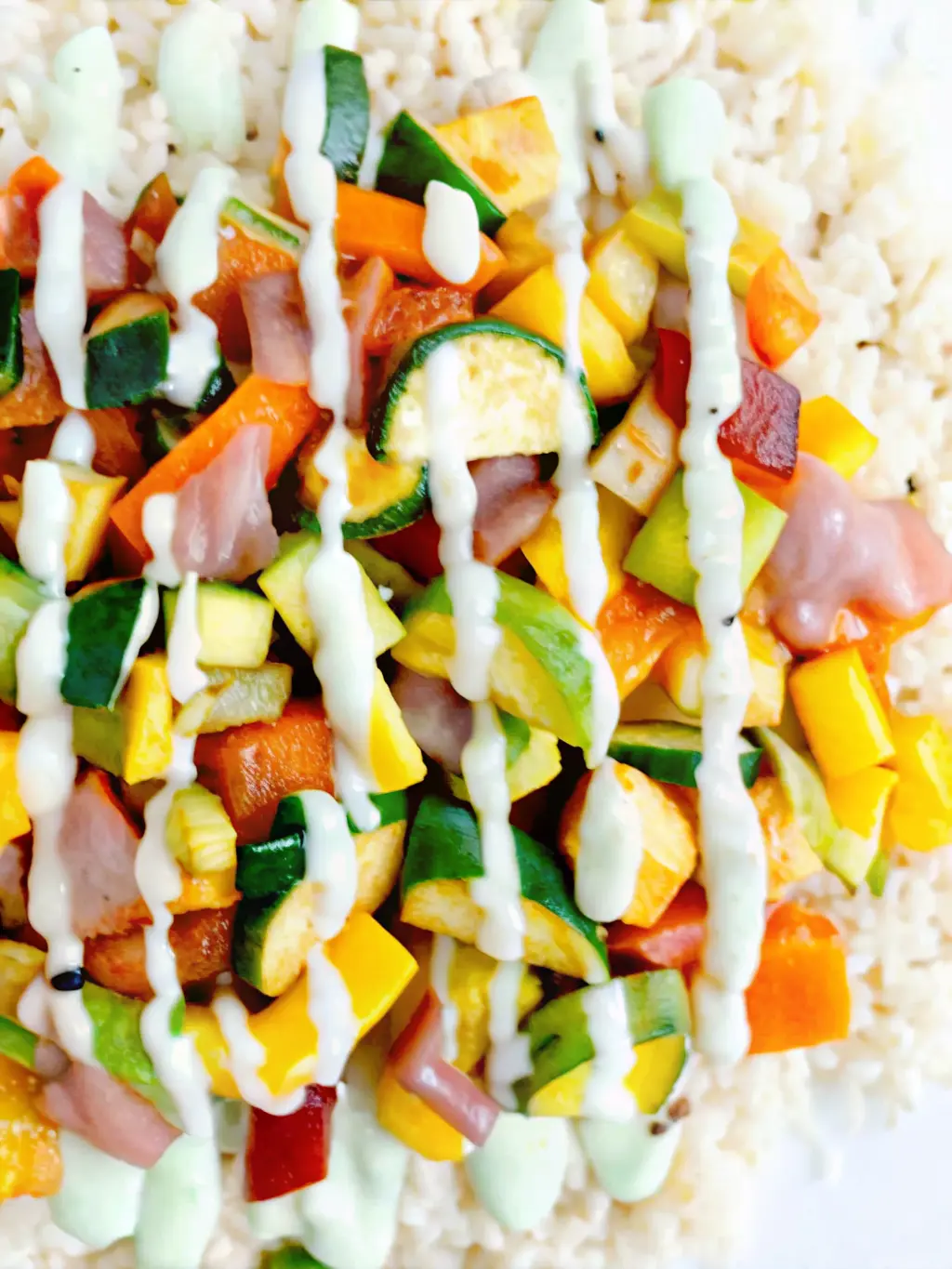 A close-up, top-down shot of vibrant, freshly chopped ingredients for roasted vegetables (diced zucchini, red, yellow bell peppers, red onion) and sauce ingredients (raw cashews, green onions, lime, cilantro, garlic) neatly arranged on a rustic wooden cutting board on a white marble countertop. Cashews are in a small white ceramic bowl. Natural morning light creates soft shadows. Clean and tidy presentation with warm tones. NO HANDS.