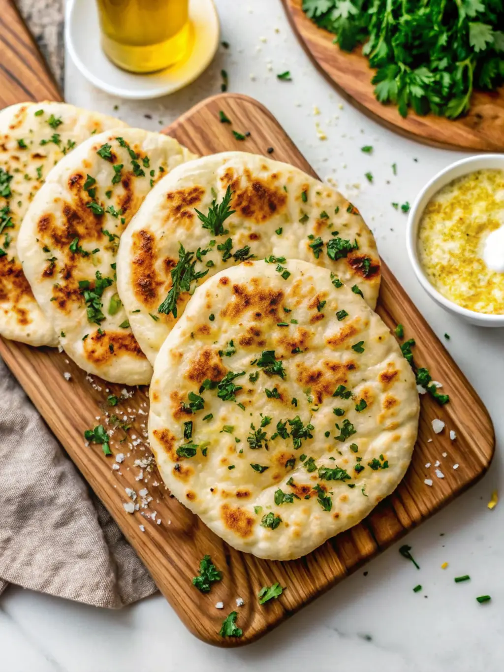 A process shot showing one golden-brown, puffed-up Fluffy Cottage Cheese Flatbread cooking in a hot cast iron skillet on a stovetop, with a slight sizzle. The flatbread has charming darker spots. The surrounding marble countertop and wooden cutting board are visible in the background, with natural morning light. Soft shadows, warm tones, no hands or people. (3:4 ratio)