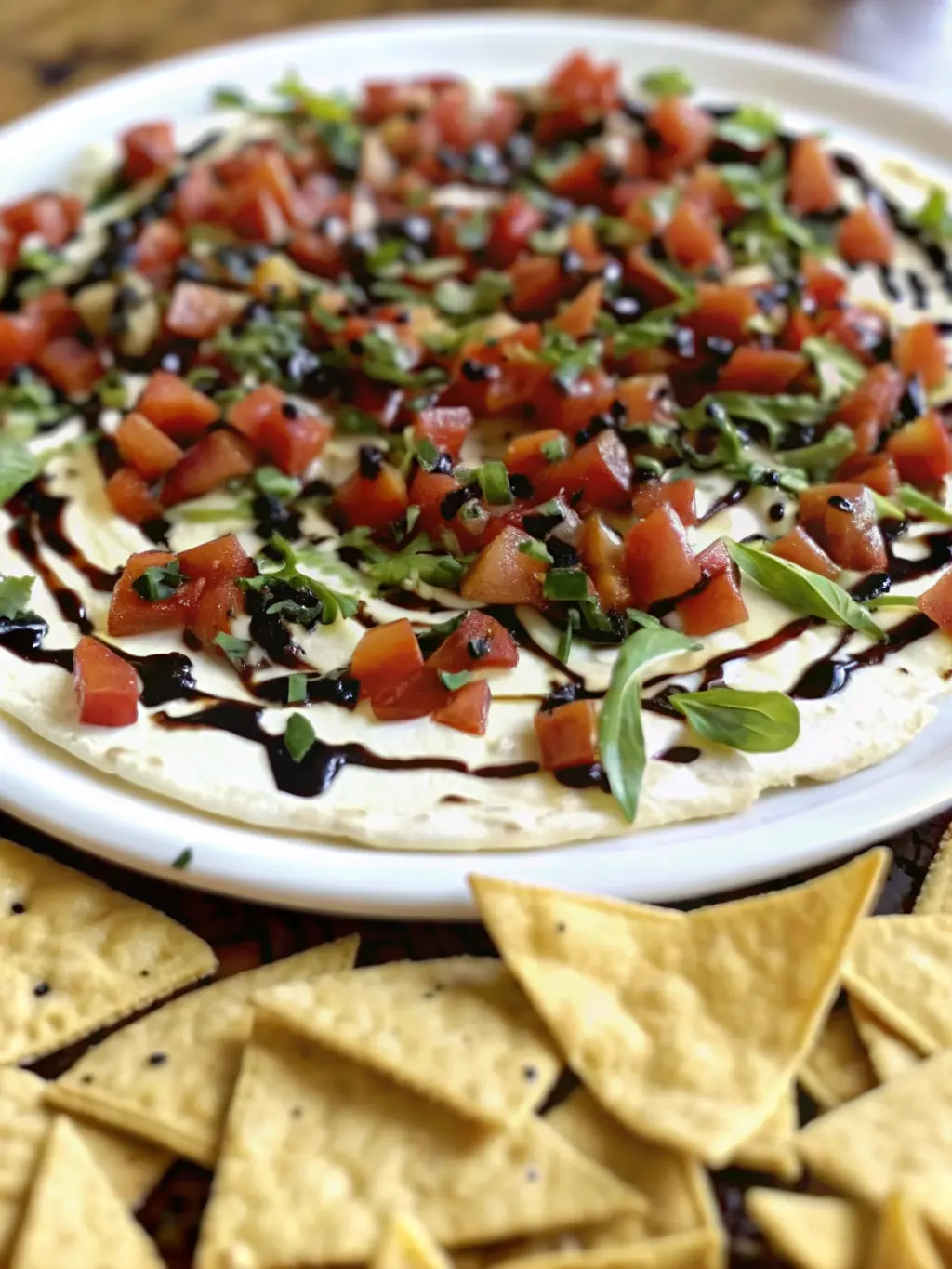 A minimalist white ceramic bowl showing the creamy white base of the Bruschetta Dip being spread, with a partially drizzled layer of golden olive oil and dark balsamic glaze, before the diced red Roma tomato and fresh green basil topping is added. Shot from a slight angle on a marble countertop, with natural morning light from an east window. Soft shadows, warm tones, clean and tidy presentation. NO HANDS OR PEOPLE. (3:4 ratio)